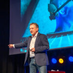 Holger Hagenlocher auf einer Bühne bei einer Keynote zum Thema KI