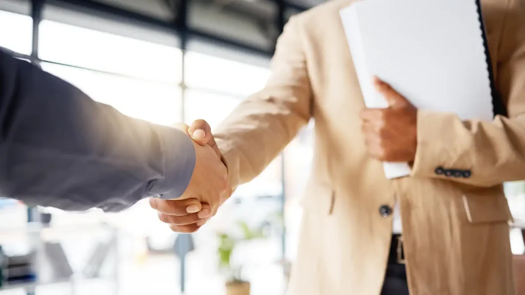 Zwei Geschäftspartner besiegeln eine Zusammenarbeit mit einem Handschlag